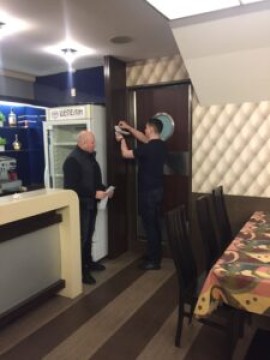 На малюнку два чоловіка в приміщенні кафе