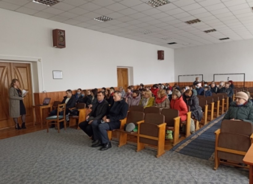 На малюнку зображені люди в актовій залі