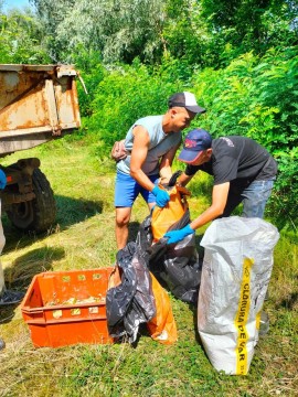 на фото дві людини складають рибу в ящики