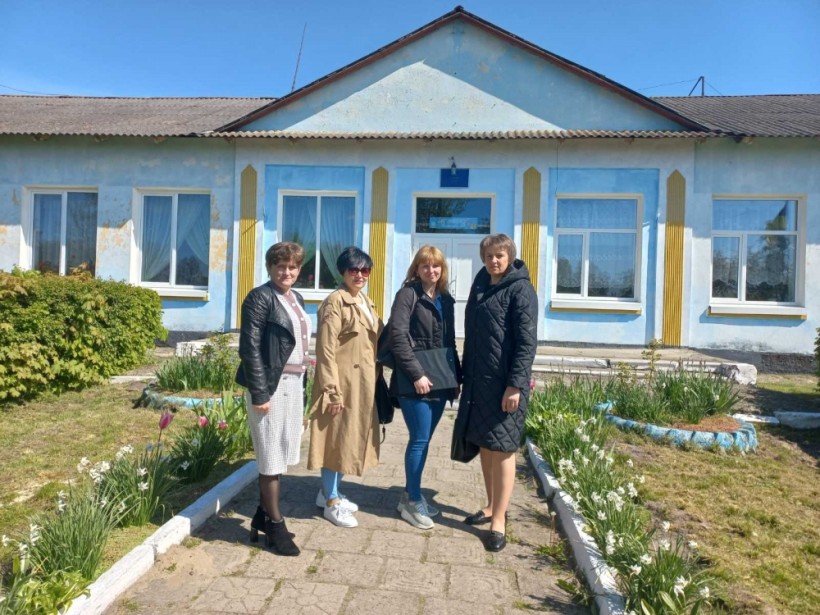 на малюнку - чотири жінки на фоні будівлі школи