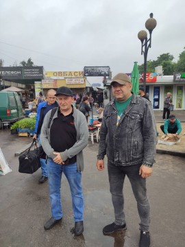 на фото дві людини при вході на ринок