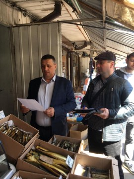 на малюнку - два чоловіка біля прилавка з рибою