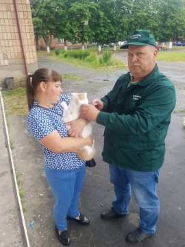 на фото дві людини і кіт