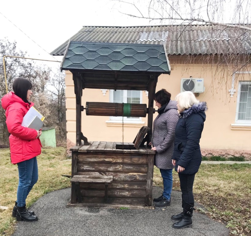 На малюнку зображені три жінки біля криниці