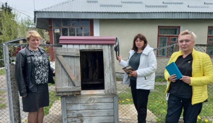 на малюнку - три людини біля криниці