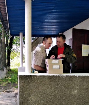 на малюнку - дві людини з коробками