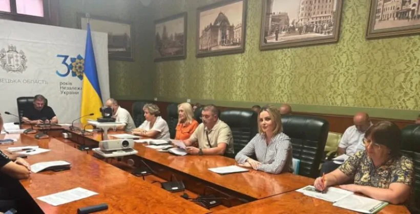 на фото зображені учасники заходу за довгим столом