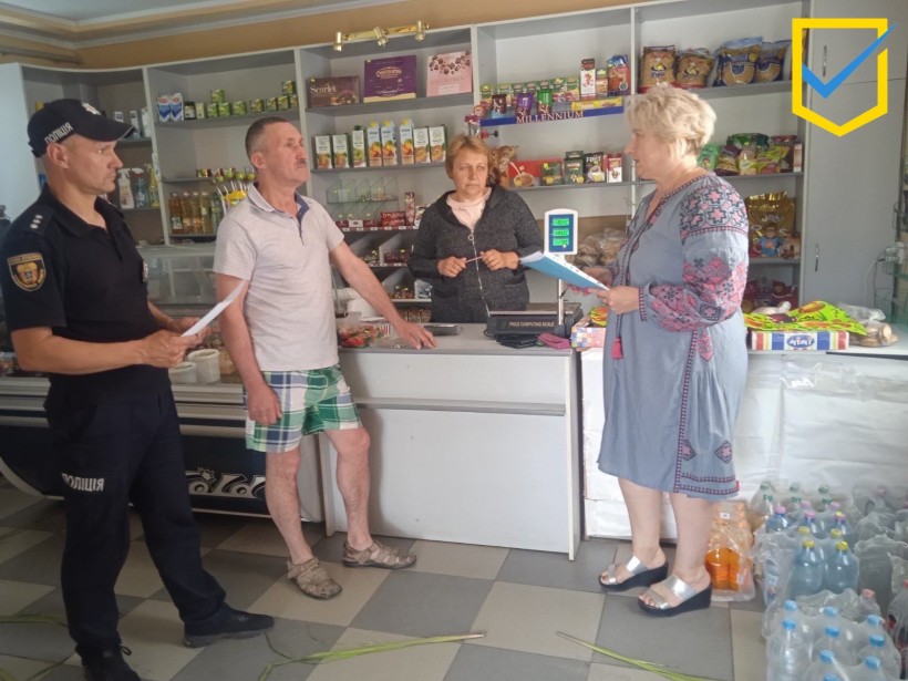 на фото - чотири людини в продовольчому магазині