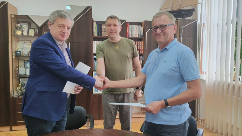 на фото три чоловіка в кабінеті