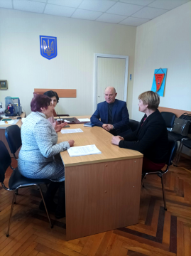 На фото зображені учасники наради в кабінети за столом.