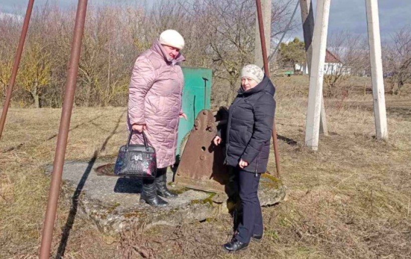 На малюнку зображено фахівчинь, що перевіряють об'єкт водопостачання