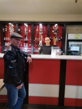 На малюнку два чоловіки в приміщенні бару