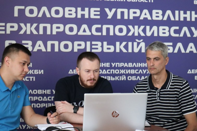 на фото - три чоловіка перед компютером