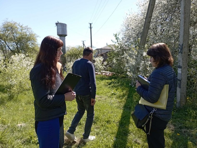 на малюнку - три людина на фоні водонапірної башти