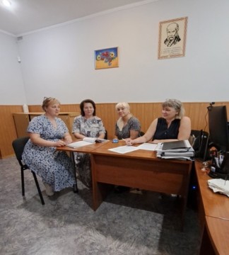 на фото чотири людини за столом в кабінеті