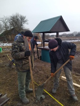 На малюнку зображено двох чоловіків біля колодязя