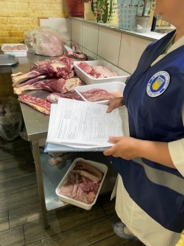 на фото співробітник ДПСС перед лотками з м'ясом