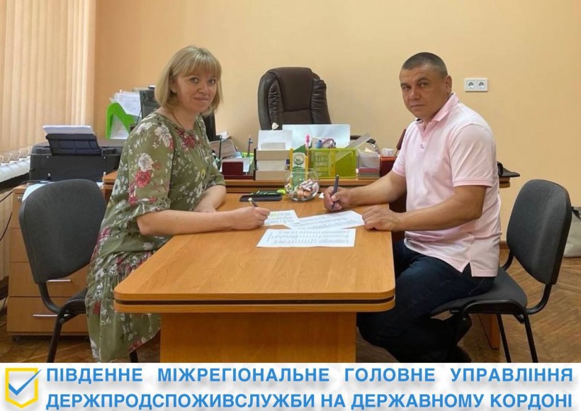 на фото дві людини за столом в кабінеті