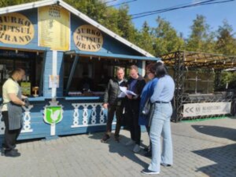 на малюнку -0 чотири людини біля кіоску з фаст-фудом