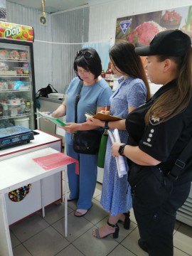 на фото три людини в магазині