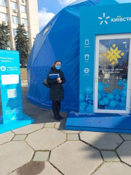 На малюнку зображено фахівчиню Держпродспоживслужби біля павільйону
