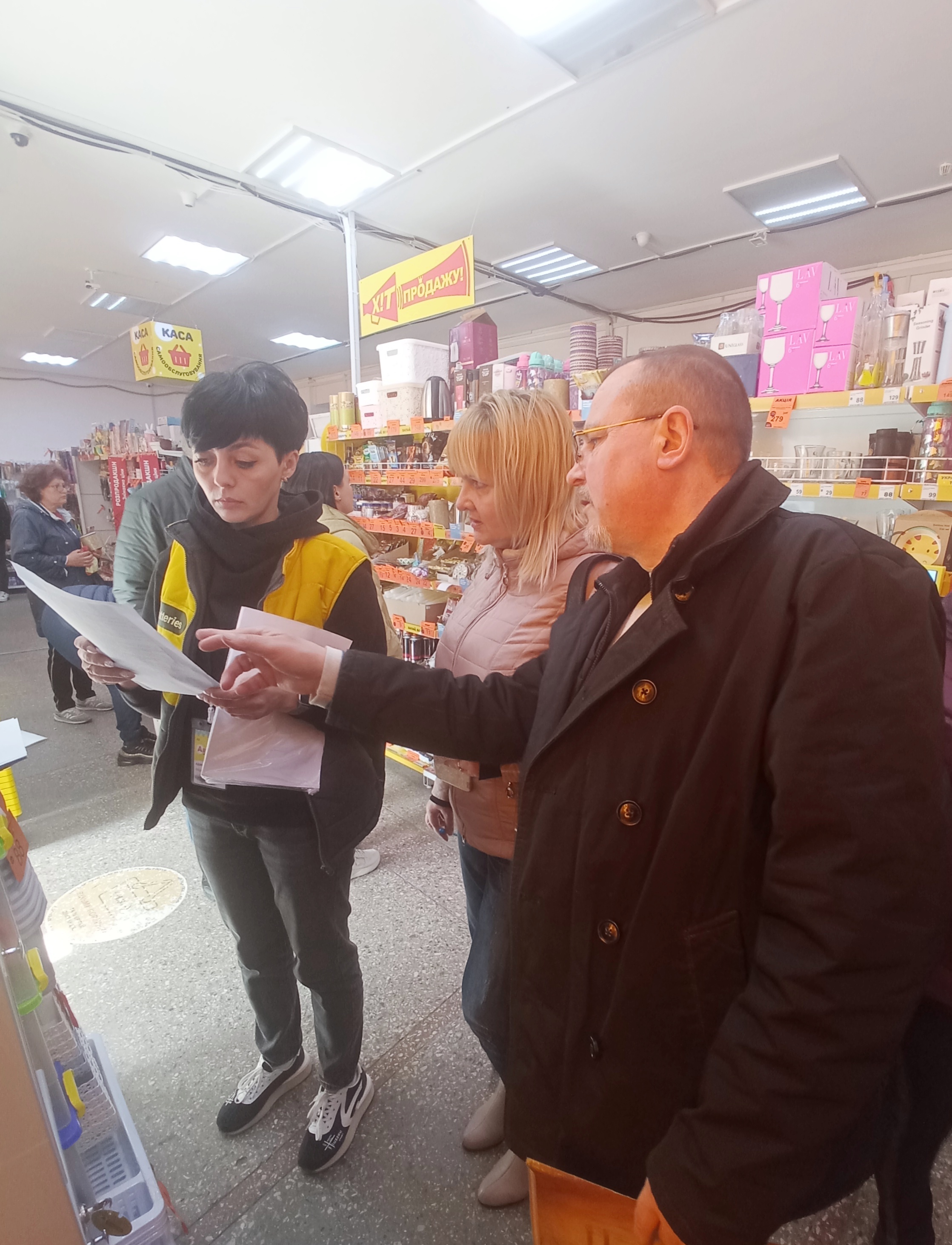 на малюнку люди в супермаркеті читають документи