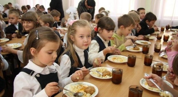 На малюнку зображені учні за обідом у шкільній їдальні