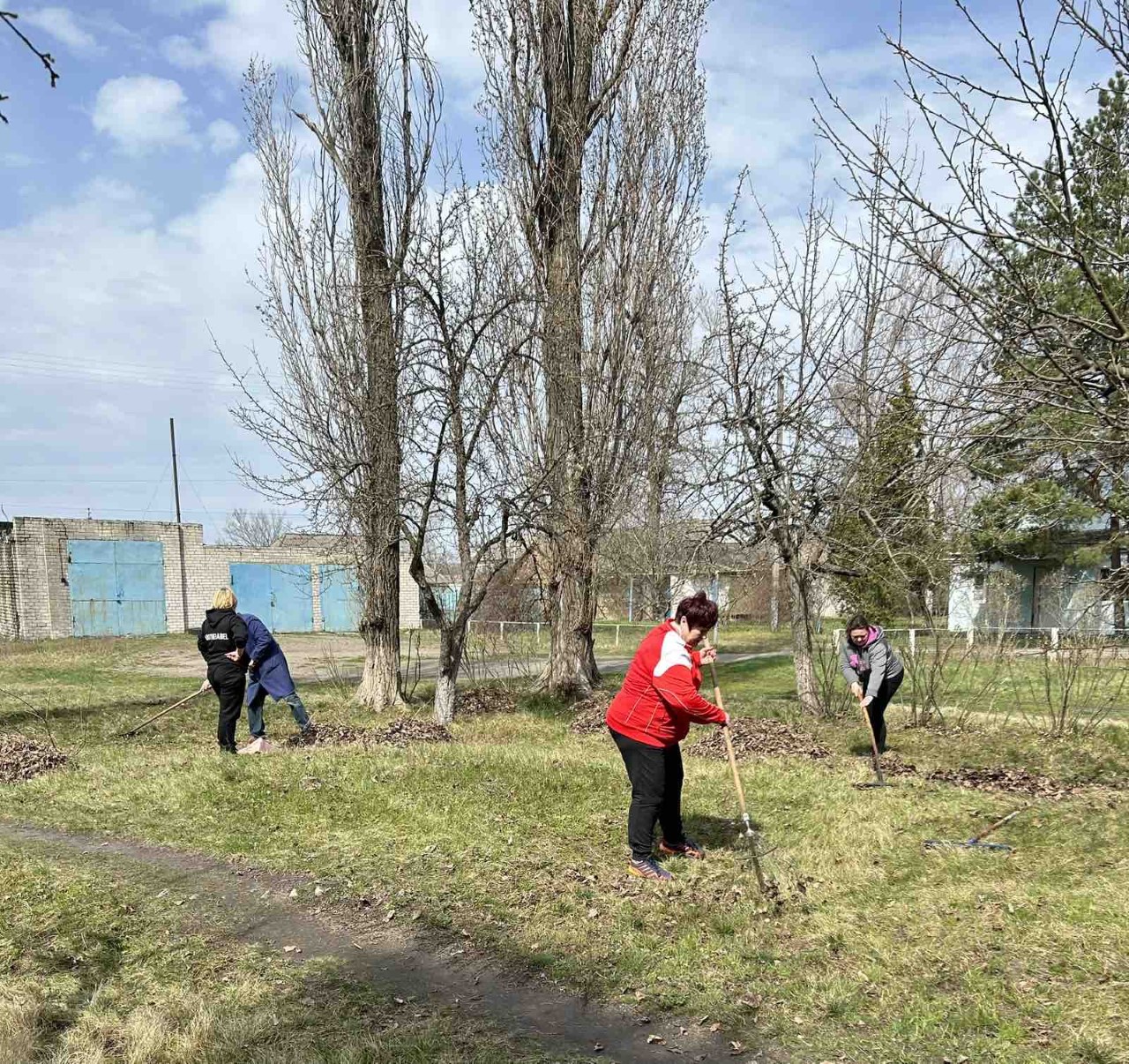 На малюнку люди прибирають в саду