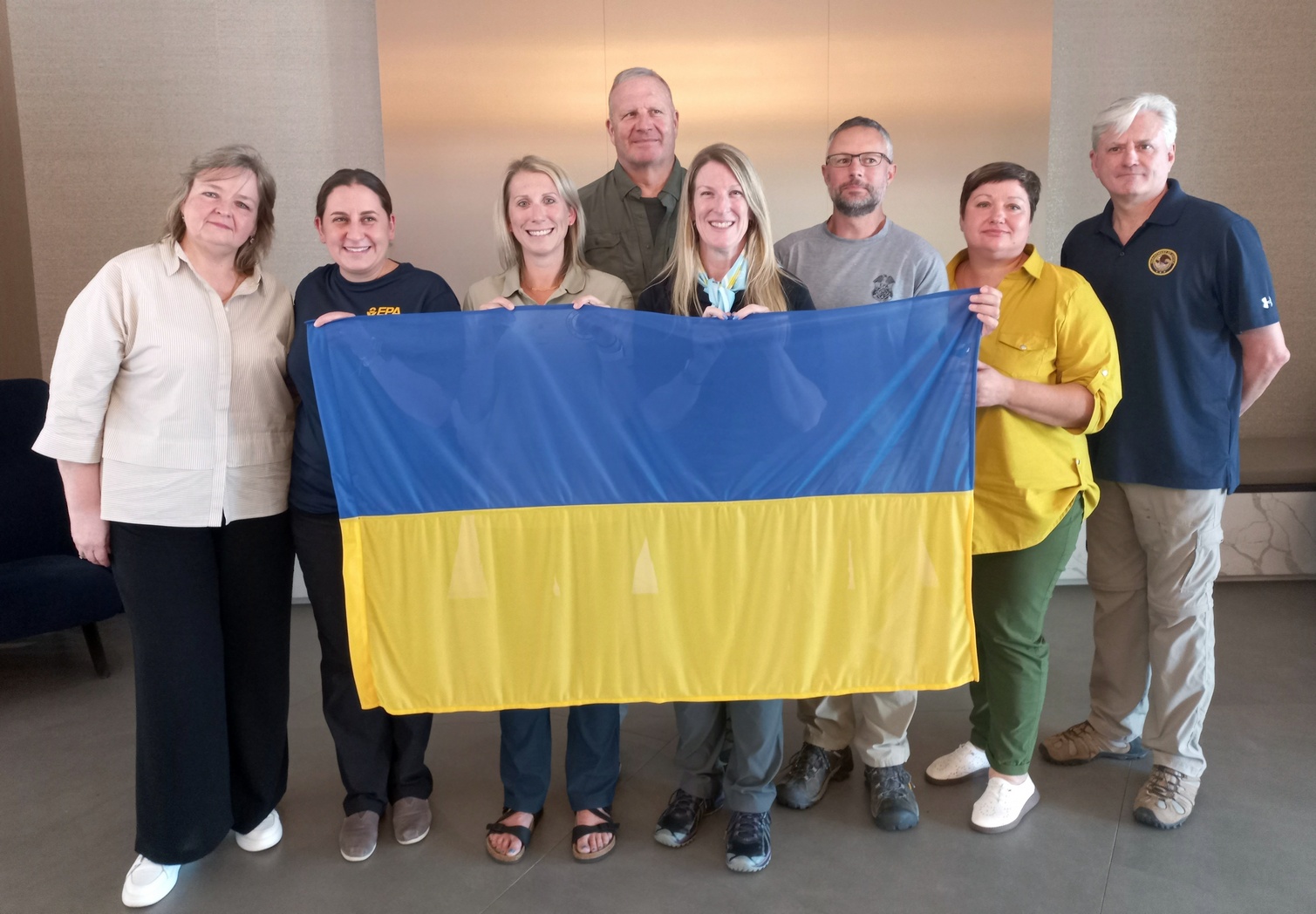 на фото 7 людей тримають прапор України